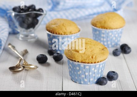 Muffin con mirtilli freschi su bianco tavolo in legno Foto Stock