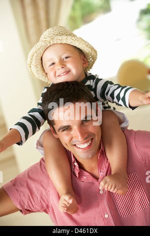 Padre dando figlio Ride su spallamenti interni Foto Stock