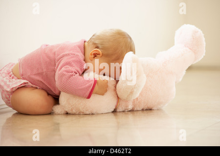 Baby girl coccole Rosa Orsacchiotto a casa Foto Stock