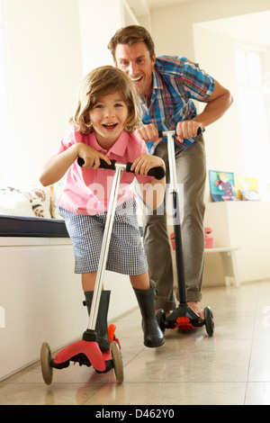 Padre e figlio in sella scooter in ambienti interni Foto Stock