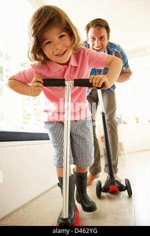 Padre e figlio in sella scooter in ambienti interni Foto Stock