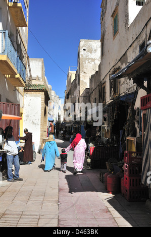 La popolazione locale a piedi attraverso le strade di mercato della fortificata città costiera di Essaouira, Marocco, Africa del Nord Foto Stock