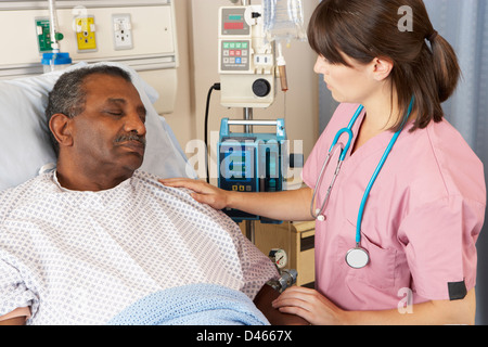 Infermiere Senior di controllo paziente di sesso maschile su Ward Foto Stock