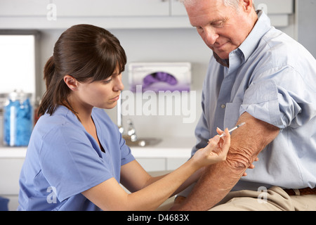Medico dando maschio iniezione del paziente Foto Stock