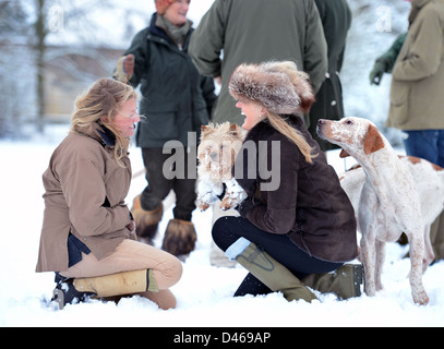 Due signore sollevare i loro Norfolk Terrier cane lontano da curiosi hounds nel corso di una riunione del Beaufort Hunt nel Parco di Badminton Foto Stock