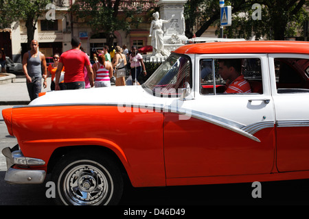 Giovane uomo alla guida di una ben dipinto anni cinquanta la vettura americana in Havana Cuba, le vetture sono spesso indicati come "Yank tanks'. Foto Stock