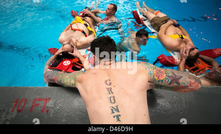 Un marine statunitense istruttore dimostra la tecnica adeguata per trattare la testa, il collo e le lesioni spinali in acqua durante la Marine Corps Swim Instructor Marzo 5, 2013 al Marine Corps base Camp Lejeune, NC. Foto Stock