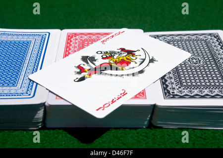 Tre diversi colori di mazzi di carte con un Joker rosso attraverso. Foto Stock