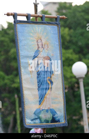 Spettacolo di fede: banner ricamato che mostra la Vergine Maria con il bambino Gesù Cristo, tenuto aloft durante una processione cattolica Foto Stock