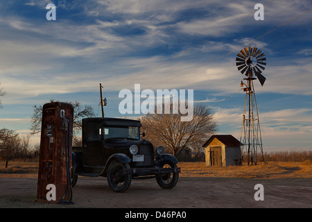 Vecchio modello T Farm carrello e il mulino a vento in una fattoria in Texas, Stati Uniti d'America Foto Stock