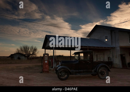 Vecchio modello T Farm carrello e il mulino a vento in una fattoria in Texas, Stati Uniti d'America Foto Stock