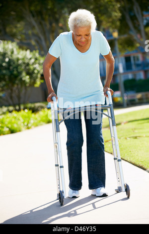 Senior donna con telaio a piedi Foto Stock