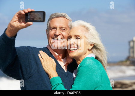 Coppia senior con la fotocamera sulla spiaggia Foto Stock