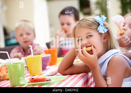 Un gruppo di bambini all'aperto godendo di Tea Party Foto Stock