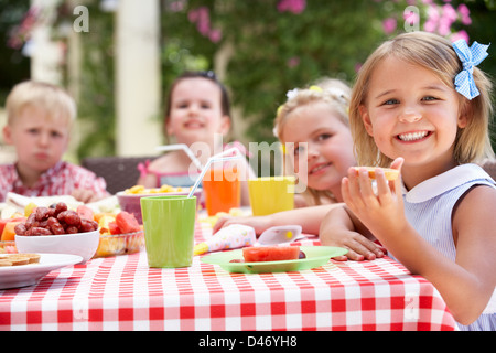 Un gruppo di bambini all'aperto godendo di Tea Party Foto Stock