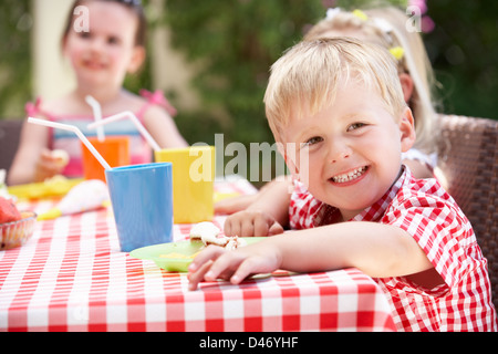 Un gruppo di bambini all'aperto godendo di Tea Party Foto Stock