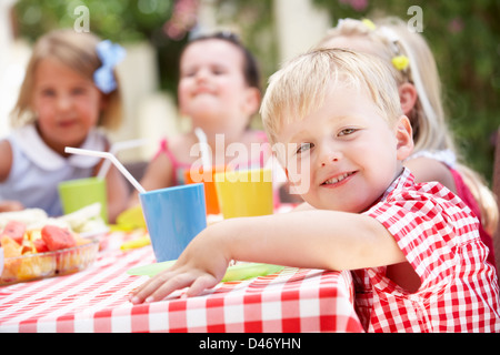 Un gruppo di bambini all'aperto godendo di Tea Party Foto Stock