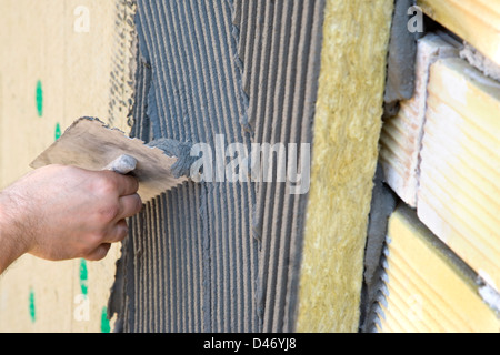 Applicazione del rivestimento di isolamento, muro di mattoni, batting Foto Stock