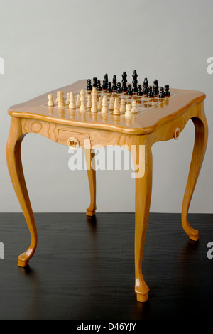 Bellissimo tavolo in legno a giocare a scacchi con i pezzi disposti Foto Stock