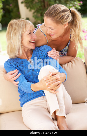 Senior donna con la figlia adulta rilassante sul divano di casa Foto Stock