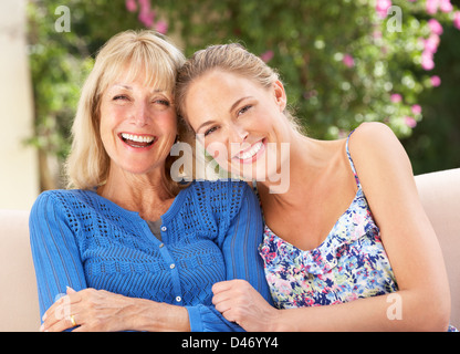 Senior donna con la figlia adulta rilassante sul divano di casa Foto Stock