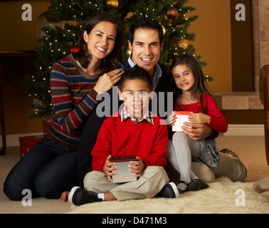Famiglia nella parte anteriore dell albero di Natale Foto Stock