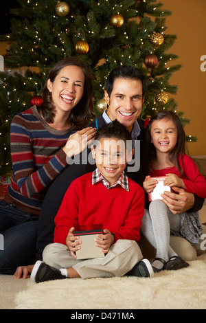 Famiglia nella parte anteriore dell albero di Natale Foto Stock