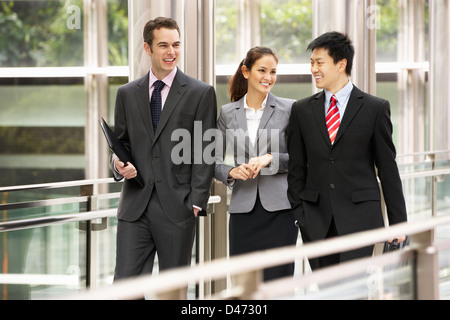 Tre colleghi di lavoro avendo discussioni mentre passeggiate al di fuori ufficio Foto Stock
