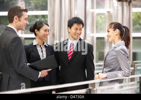 Quattro colleghi di lavoro avente la discussione al di fuori ufficio Foto Stock