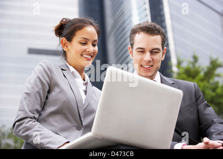 Imprenditore e imprenditrice lavorando su laptop fuori ufficio Foto Stock