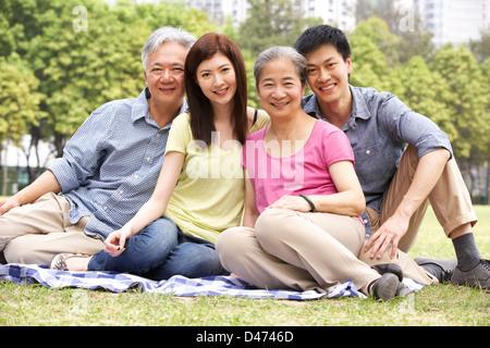 Ritratto di genitori cinesi con figli adulti Relax nel parco insieme Foto Stock