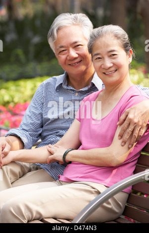 Senior coppia cinese relax su una panchina nel parco insieme Foto Stock