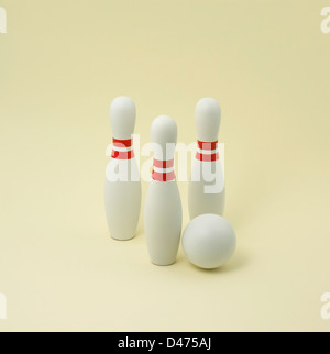 Tre bianco e rosso birilli con sfera tagliata su sfondo bianco Foto Stock