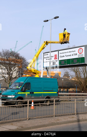 Lavoratori del Consiglio che mantengono i semafori su una strada a doppia carreggiata da un ascensore aereo montato su un furgone del Consiglio cittadino di Glasgow, Scozia, Regno Unito Foto Stock