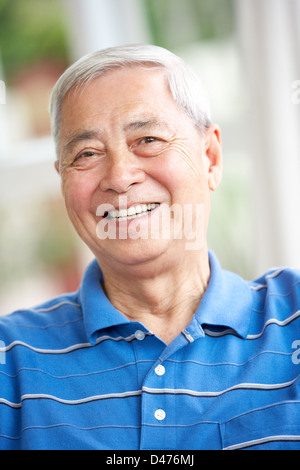 Senior uomo cinese rilassante sul divano di casa Foto Stock