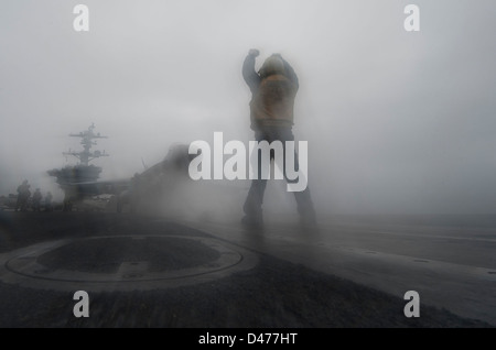 Sailor dirige un'F/A-18E Super Hornet a bordo della USS Carl Vinson Foto Stock