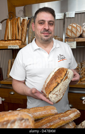 Il panettiere francese presentando la sua " pain de Meule'. Focacce e pane. Foto Stock