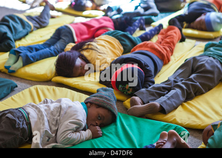 Giovane Sudafricano bambini sdraiarsi su stuoie per un sonno durante il tempo di riposo in uno sviluppo della Prima Infanzia centro di Città del Capo Foto Stock