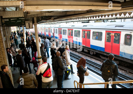 Le persone sulla piattaforma a High Street Kensington Stazione della metropolitana di Londra, Regno Unito Foto Stock