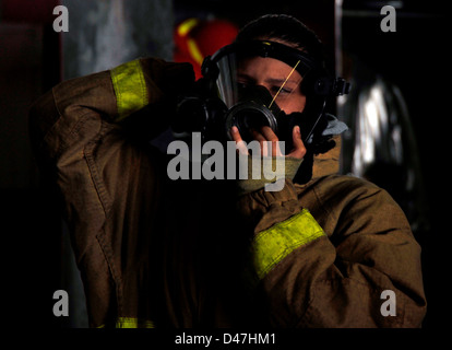 Un marinaio a bordo della USS Abraham Lincoln (CVN 72) indossa attrezzature antincendio durante un'esercitazione generale, garantendo la preparazione alle situazioni di emergenza a bordo della portaerei classe Nimitz. Foto Stock