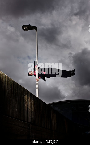 Parkour runner in tuta in equilibrio su Lampione Foto Stock