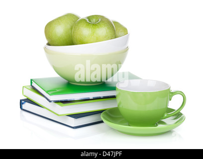 Mature mele verdi, tazza di caffè e libri. Isolato su sfondo bianco Foto Stock