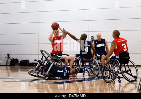 Uno Sgt. Si prepara a passare la palla durante una partita di pallacanestro in sedia a rotelle tra il corpo dei Marine e la Marina/Guardia Costiera ai Giochi dei Guerrieri del 2012. Foto Stock