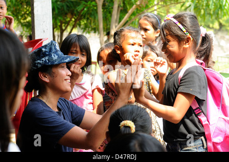 La USS Blue Ridge visita l'Indonesia, dove i membri dell'equipaggio partecipano a eventi di servizio della comunità, tra cui attività di raccolta rifiuti a Giacarta. Questa visita rafforza le relazioni USA-Indonesia e mette in mostra gli sforzi umanitari della Marina. Foto Stock