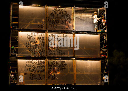 Mar 07, 2013 - Adelaide, South Australia, Australia - Compagnie Luc Amoros di eseguire la pagina vuota a prove abito rima di inizio Womadelaide 2013. Sei artisti arrampicarsi a bordo di un alto 10 metri rivestito di impalcature in perspex trasparente i pannelli e creare messaggi selvatico accompagnato da una colonna sonora dal vivo con costantemente mutevoli colori, segni, frasi di ombre e di luci. (Credito Immagine: © Gary Francesco/ZUMAPRESS.com) Foto Stock