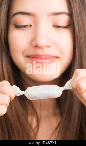 Ragazza adolescente holding candy nelle sue mani Foto Stock