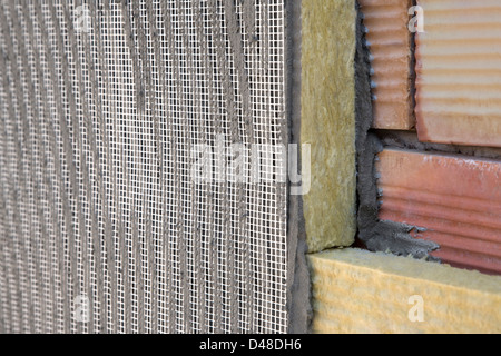 Applicazione del rivestimento di isolamento, muro di mattoni, batting Foto Stock