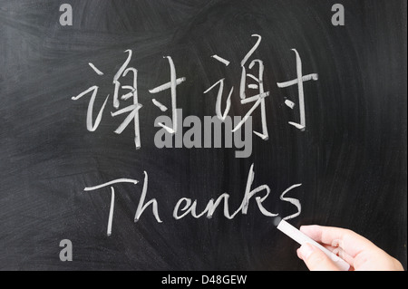 Grazie parola in lingua cinese e inglese scritto sulla lavagna Foto Stock