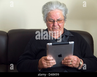 Donna anziana tramite iPad Foto Stock