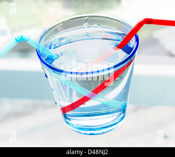 La rifrazione di una cannuccia in un bicchiere di acqua Foto stock